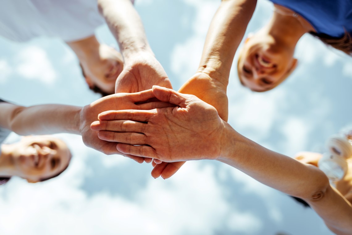 Mennesker i ring som holder hender